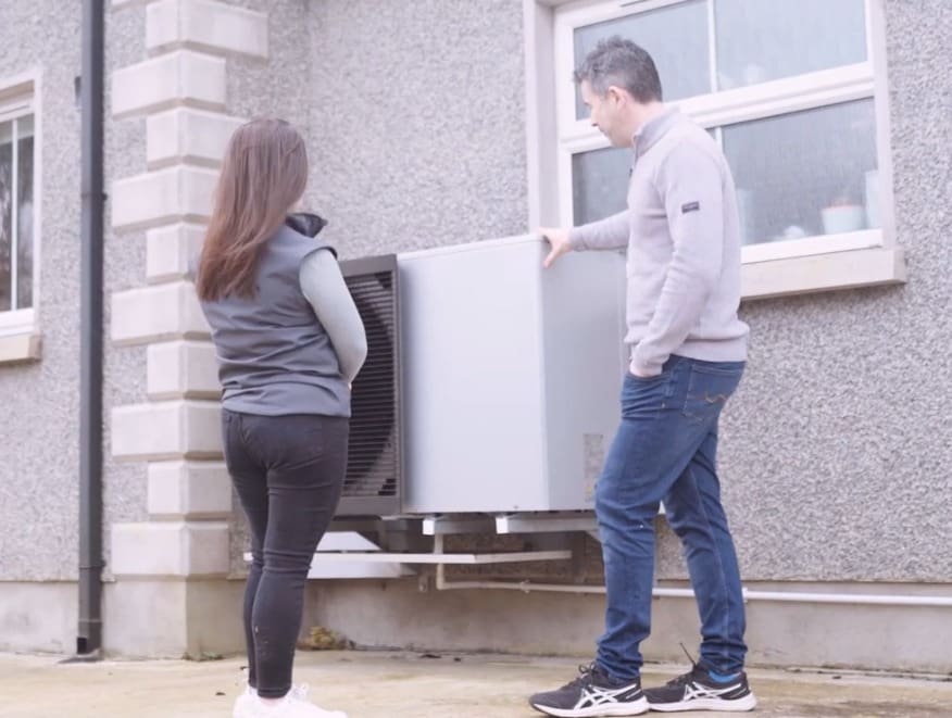 Heat Pump Case Study Preview Image of Tom beside his air to water heat pump installed by Ohk Energy.