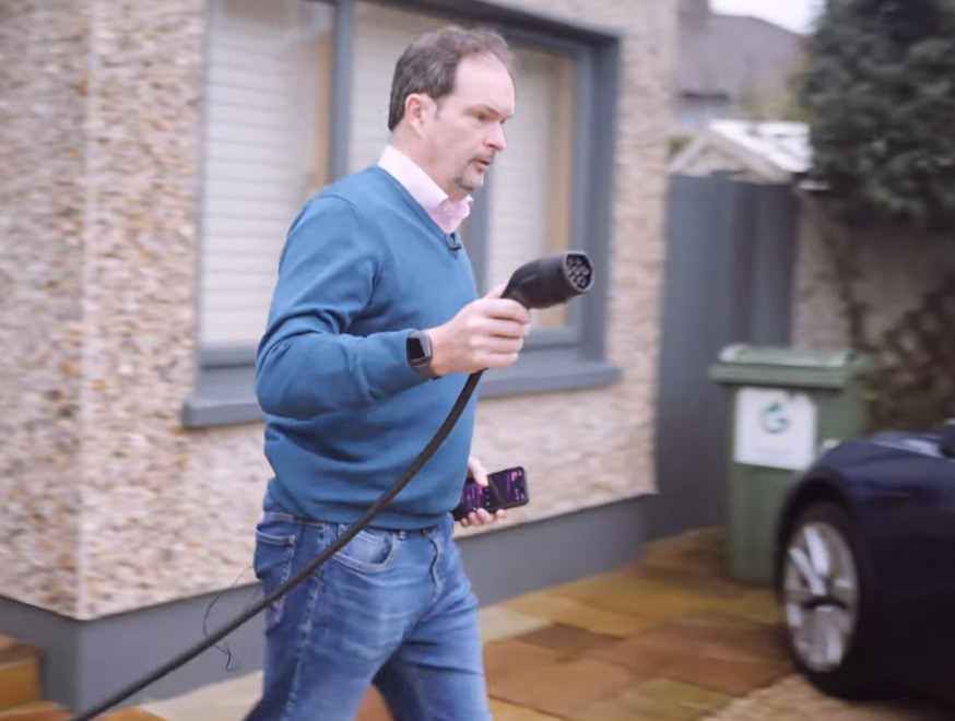 zappi EV Charger Customer Image showing an Ohk energy customer about to plug their zappi charger into their EV at home.