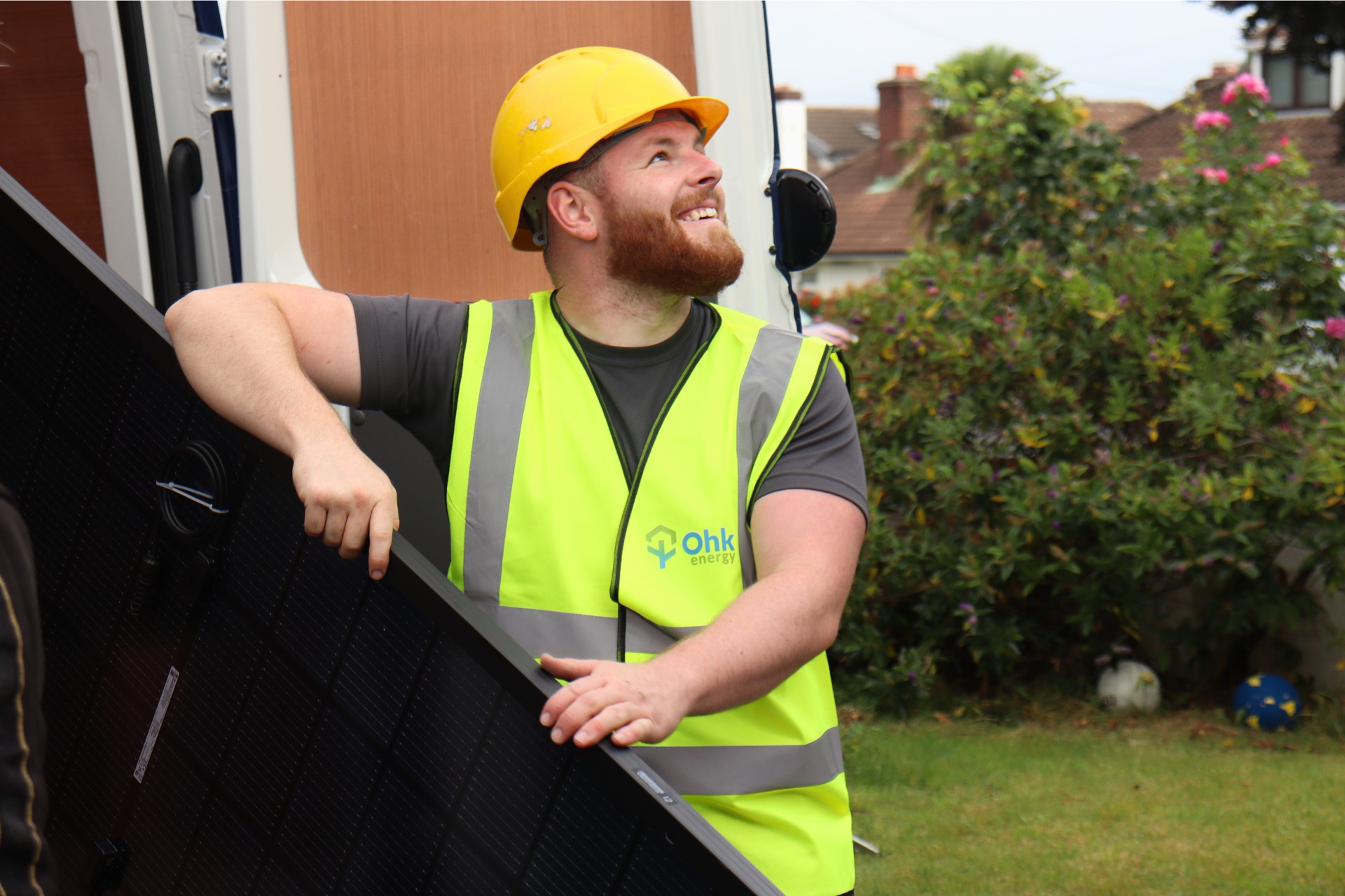 An Ohk energy solar panel installer removing a solar PV panel from a van.
