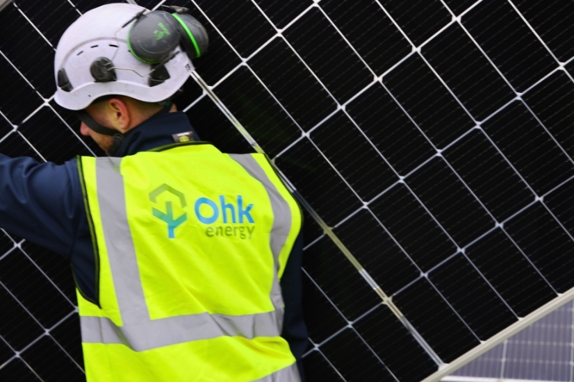 Monocrystalline Solar PV Panels Image showing an Ohk energy electrician carrying a monocrystalline solar PV panel.