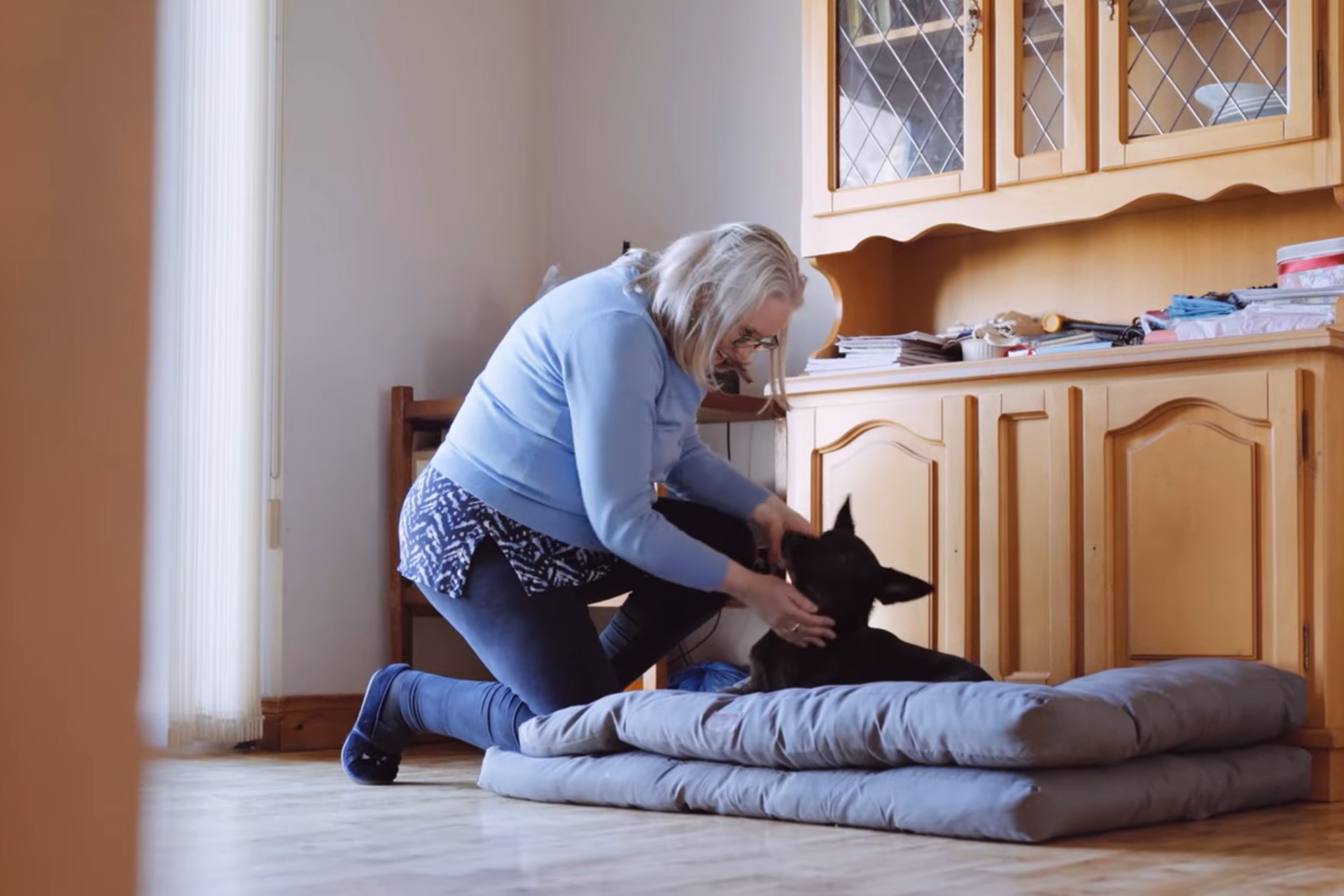 Solar Panel Installation Louth Case Study Featured Image showing and Ohk energy customer in her kitchen with her dog.