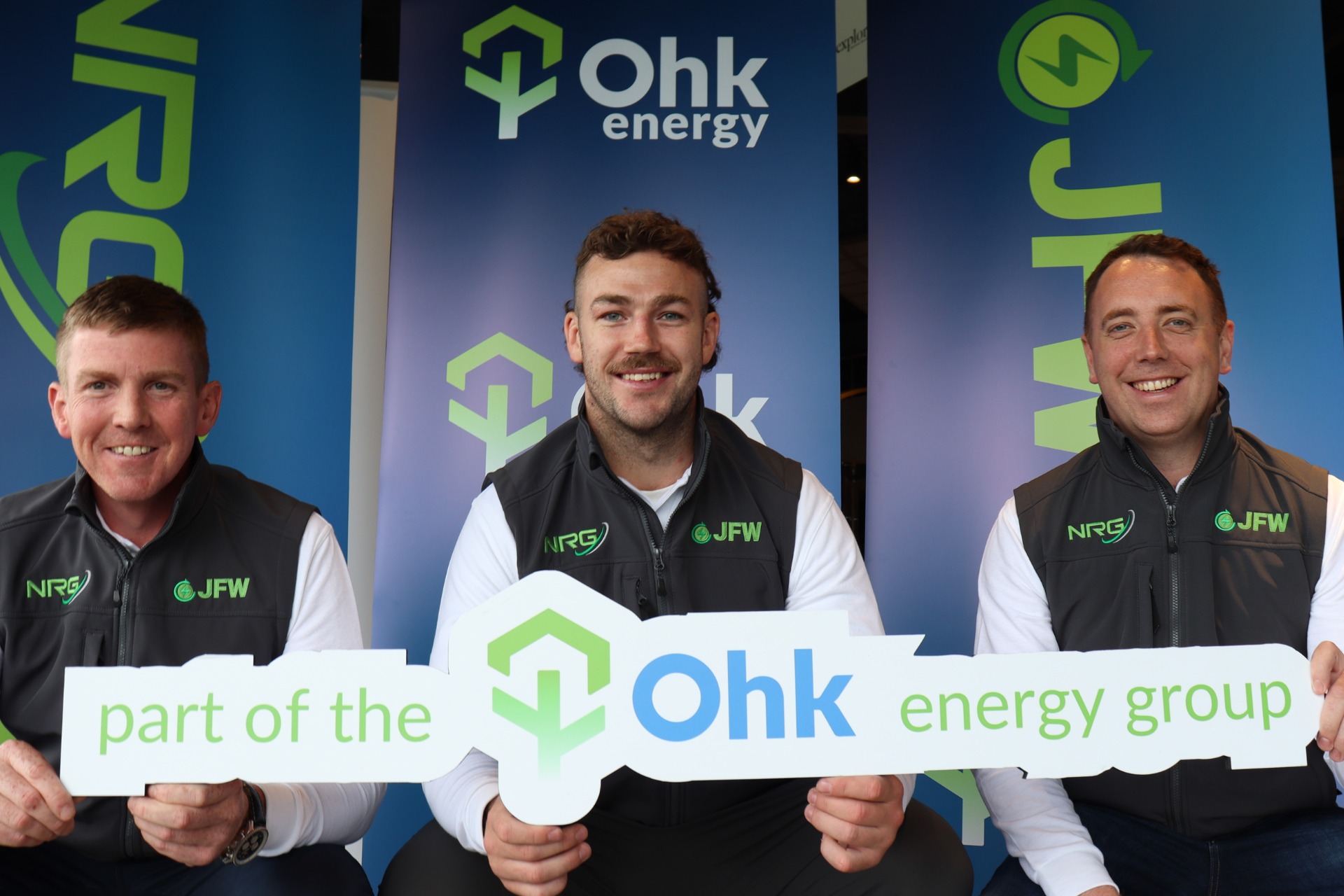 Say Hello To Ohk energy Featured Image showing Conor, Caelan and Gearoid holding a sign that reads 