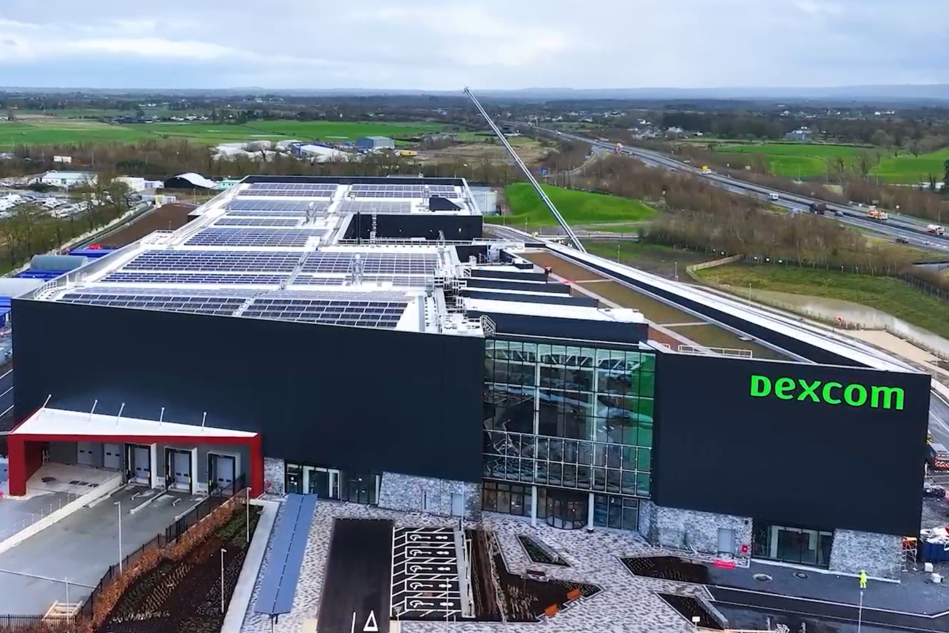 Irelands Largest Energy Resilience System Featured Image showing an arial view of Dexcom with over 2,000 solar panels installed on the roof by Ohk energy.