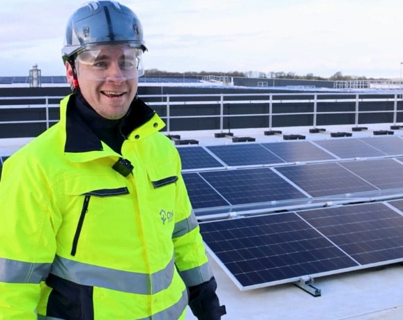 Irelands Largest Energy Resilience System Video Preview Image showing an Ohk energy representative standing in front of rooftop solar panels installed by Ohk energy.